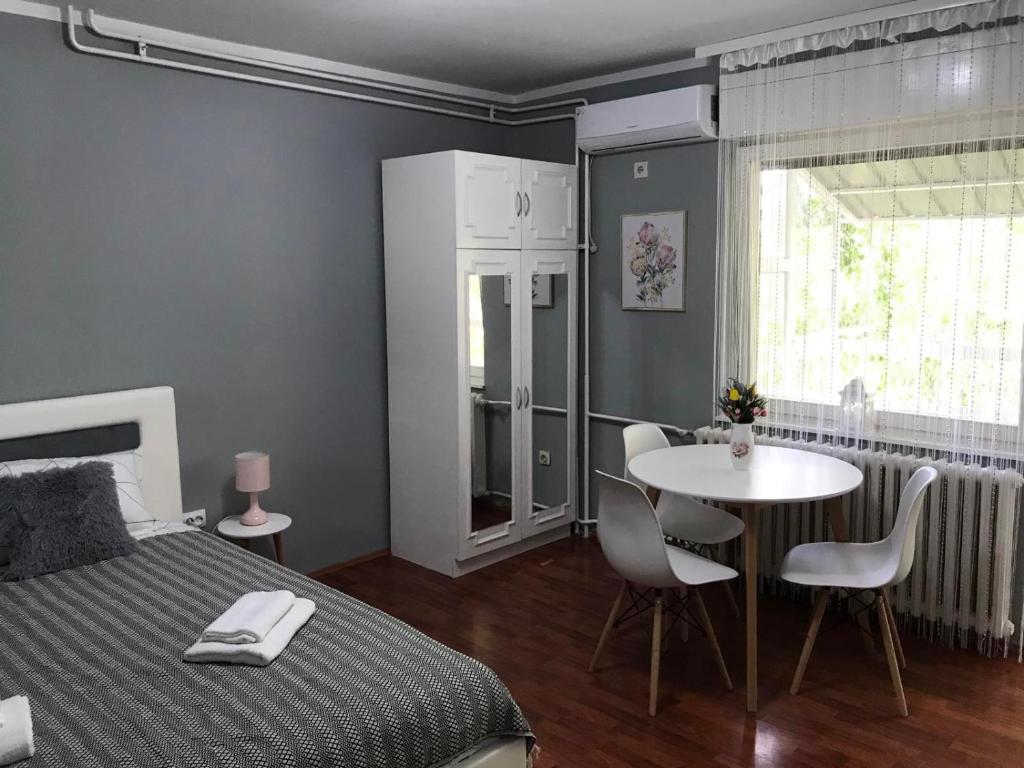 sypialnia z łóżkiem, stołem i krzesłami w obiekcie Apartman studio Pavle i Petra w mieście Sremski Karlovci