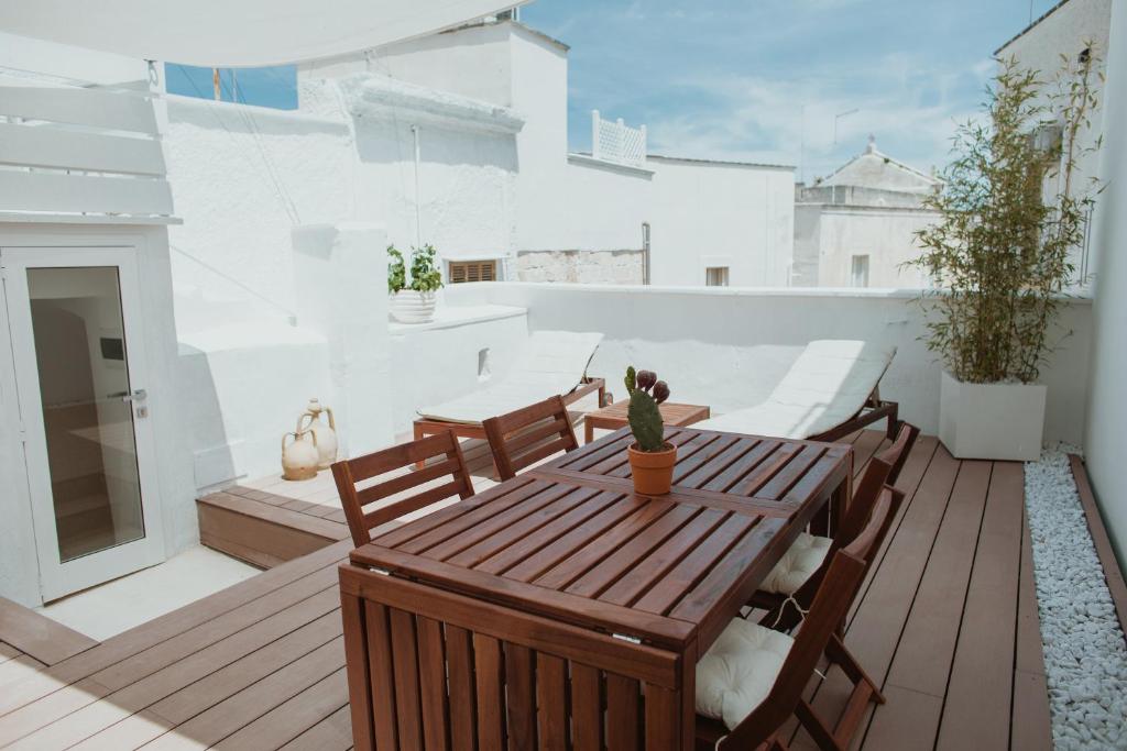 a patio with a wooden table and chairs on a balcony at Pausa Mare Suite in Monopoli