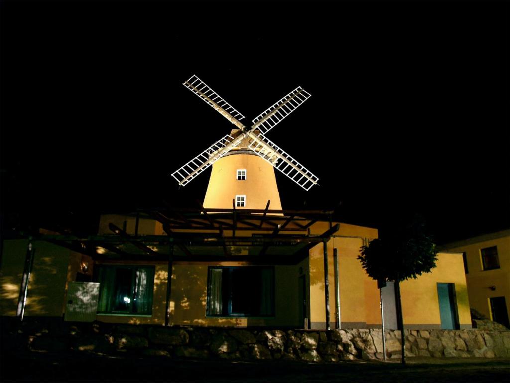 a building with a windmill on top of it at night at Doppelzimmer Gästehaus Mühlenstein in Bad Sülze