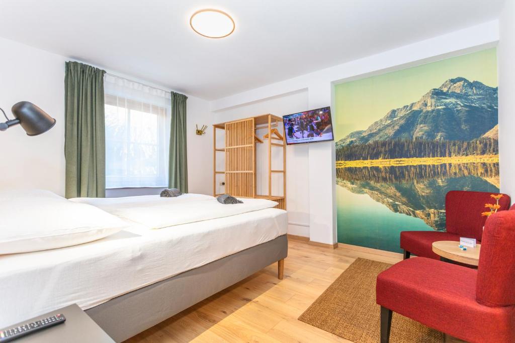 Habitación de hotel con cama grande y escritorio. en Sonnberg Lodge, en Maria Alm am Steinernen Meer