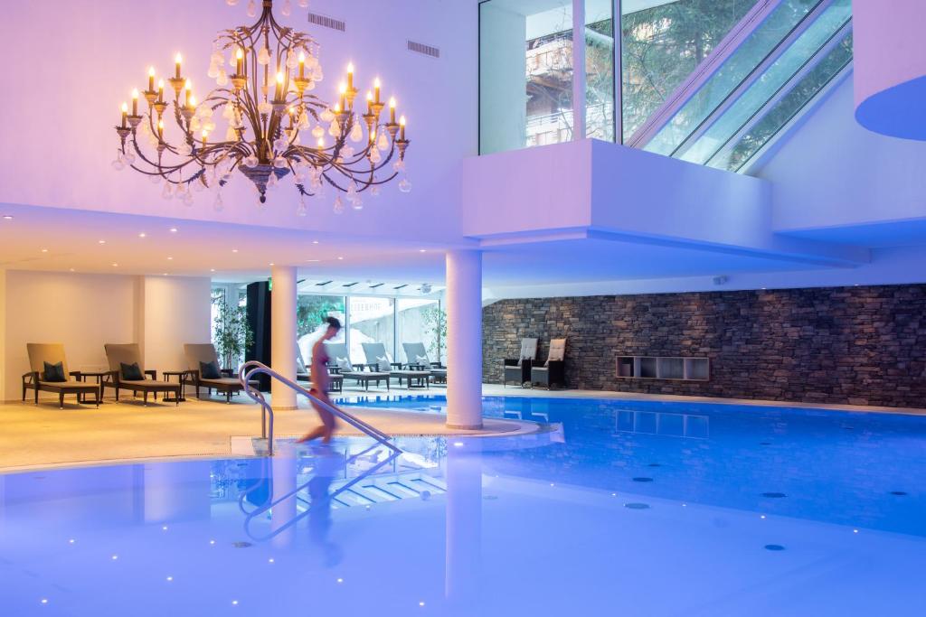 a person is playing in a swimming pool at Walliserhof Grand-Hotel & Spa Relais & Châteaux in Saas-Fee