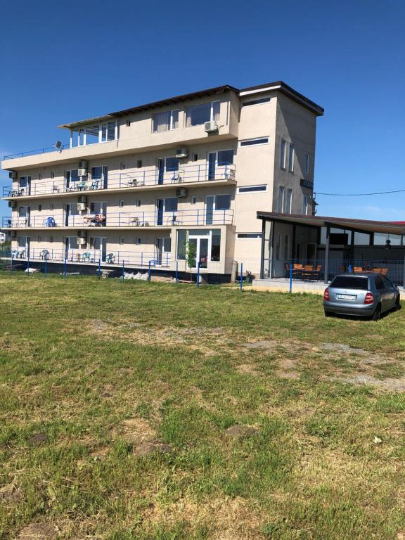 a building with a car parked in front of it at Autentic Boutikue in Costinesti