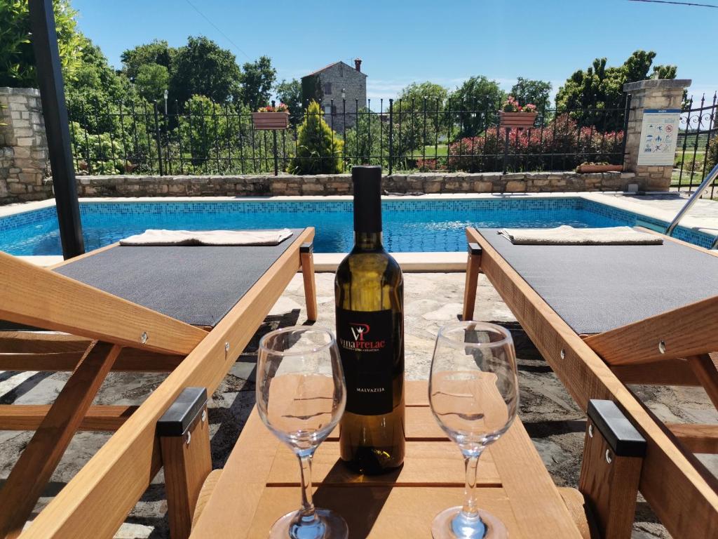 a bottle of wine sitting on a table with two glasses at Villa Rustica in Buje