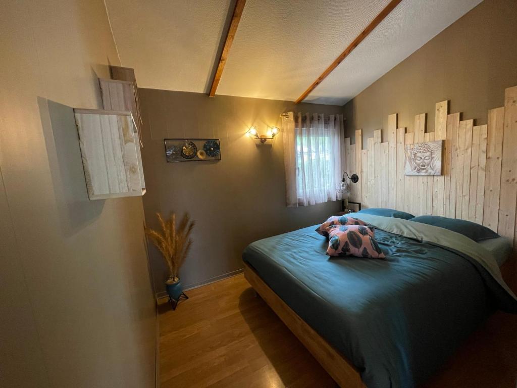 1 dormitorio con cama con sábanas azules y ventana en Chalet de l'écluse en Namur