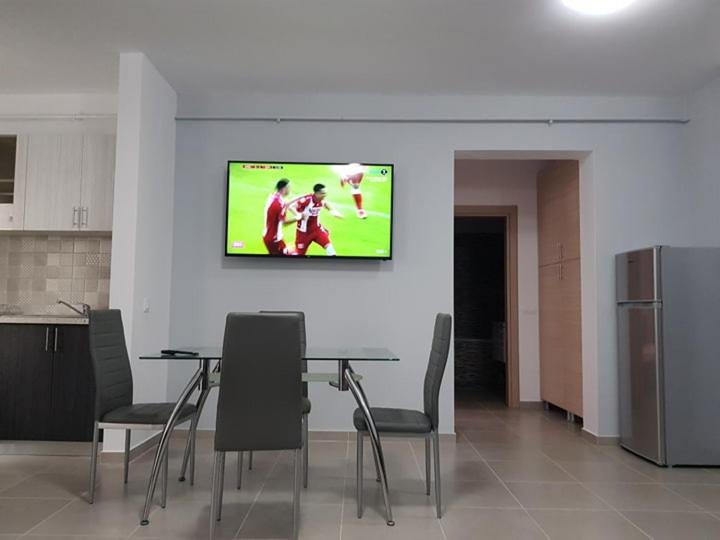 a dining room with a table and a tv on a wall at CASA ROXANA in Slatina