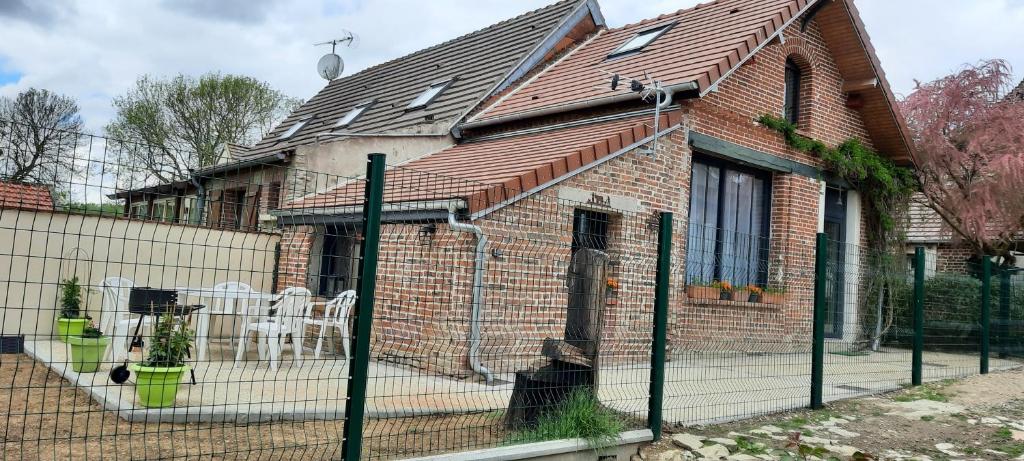 uma casa de tijolos com uma cerca em frente em L atelier des rêves em Cressonsacq