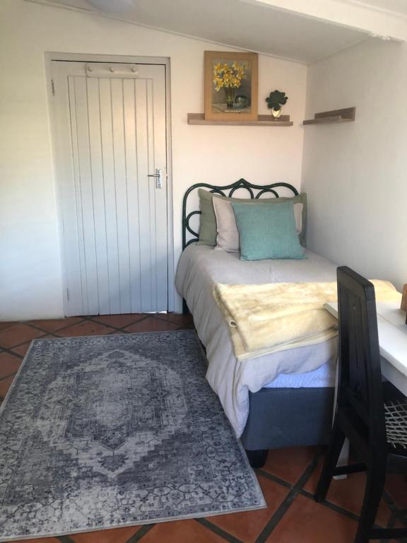 a bedroom with a bed and a chair and a door at Just a Bed in Stellenbosch
