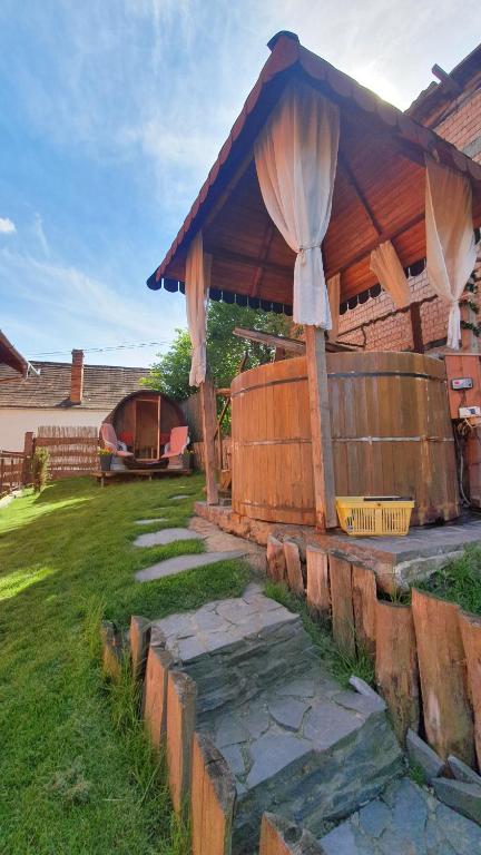 einen Garten mit einem Holzpavillon mit einem Zaun in der Unterkunft Pension Norbert in Sighişoara