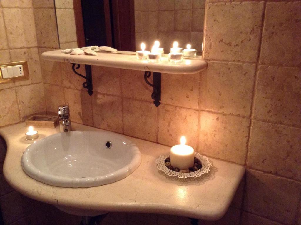 a bathroom with a sink with a candle on it at B&B DIMORA PALMIERI in Monopoli