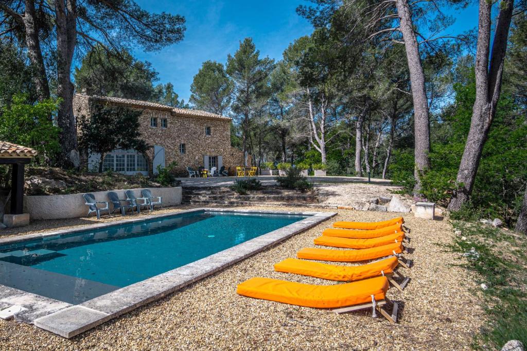 a pool with lounge chairs and a house at Stunning panoramic views and heated pool in Roussillon in Roussillon