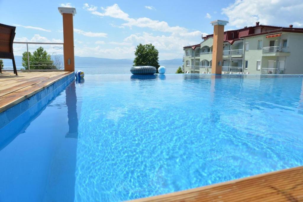a large swimming pool with blue water in front of a building at Villa Mina in Ohrid