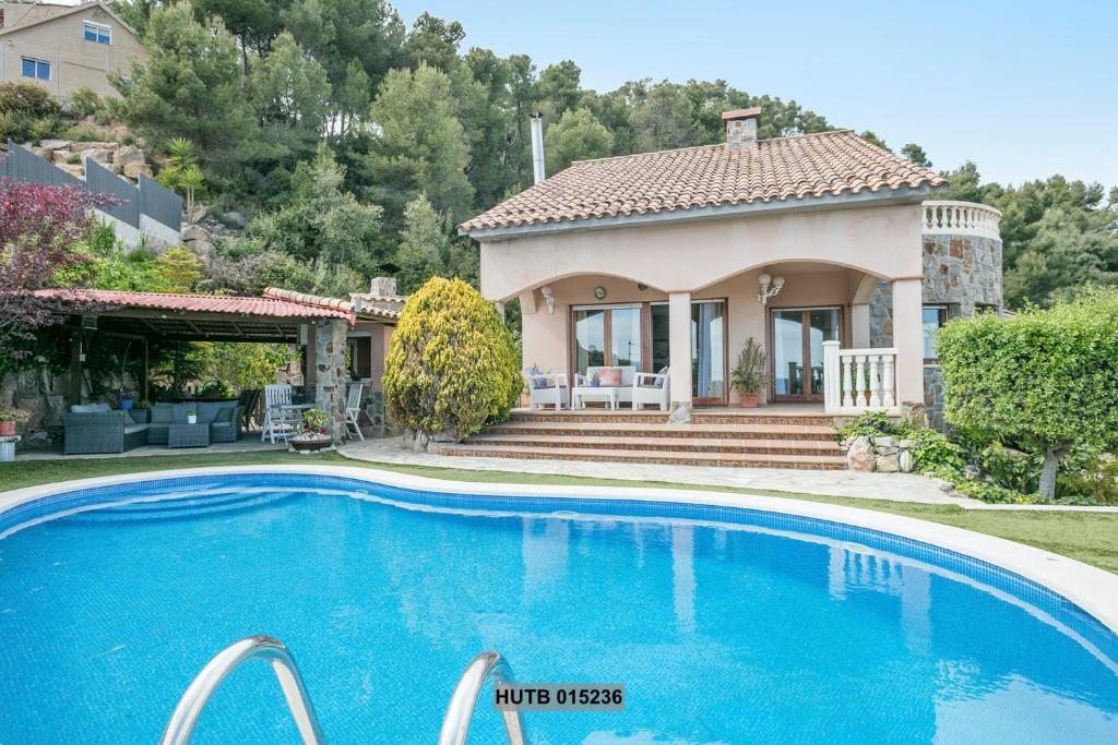 a house with a swimming pool in front of a house at Alcam Can Macia in Corbera de Llobregat