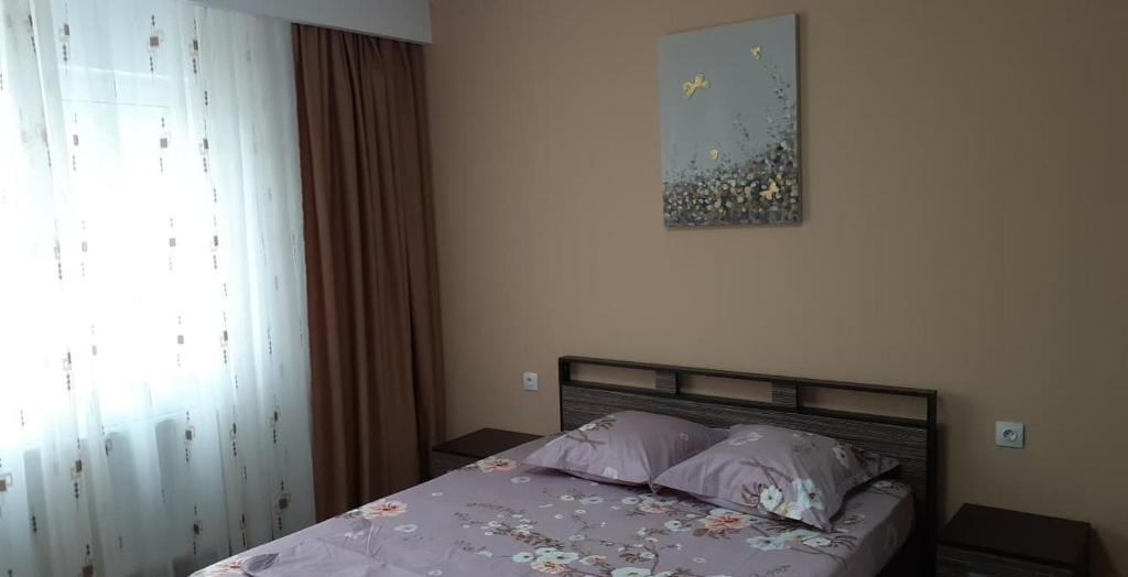 - une chambre avec un lit et une photo sur le mur dans l'établissement CASA LIVIA, à Slatina