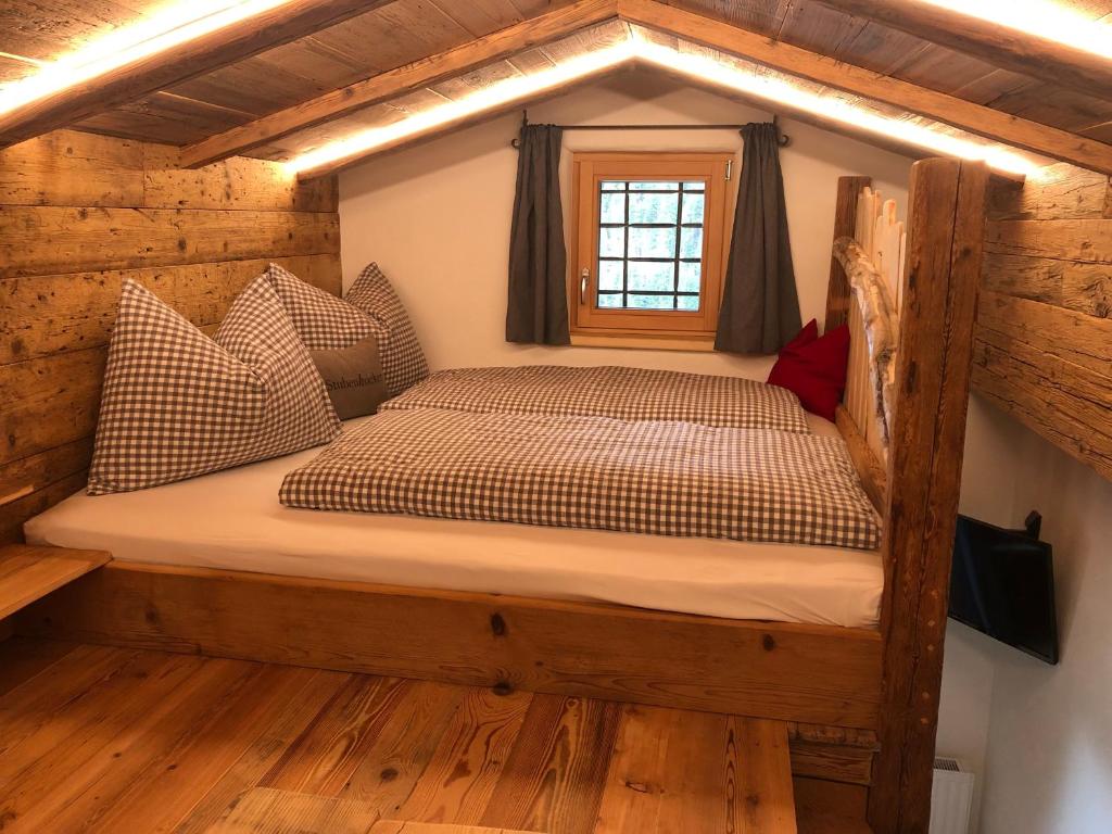 ein Schlafzimmer mit einem Bett in einem Blockhaus in der Unterkunft Haus Tannenheim in Filzmoos