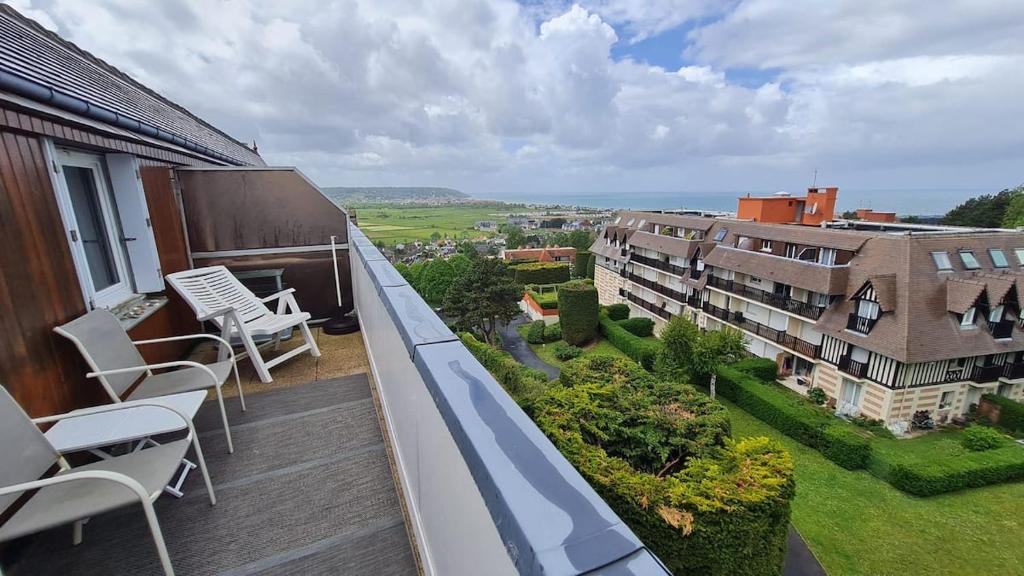 d'un balcon avec des chaises et une vue sur un bâtiment. dans l'établissement à 10 minutes à pieds de la plage, Résidence La Corniche du Mont Canisy - Traveller Award 2023, à Blonville-sur-Mer