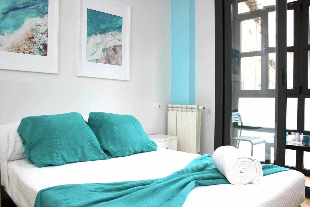 sypialnia z niebiesko-białym łóżkiem w obiekcie Apartamento Mas céntrico del Húmedo Desayuno w mieście León