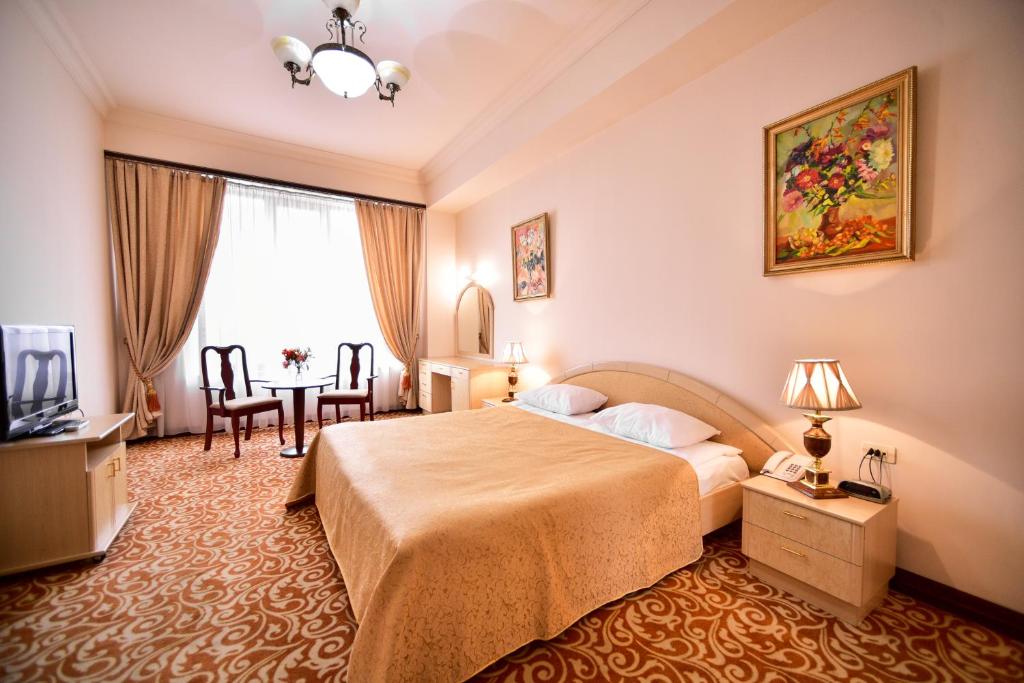 Habitación de hotel con cama y mesa en METROPOL HOTEL Yerevan en Ereván