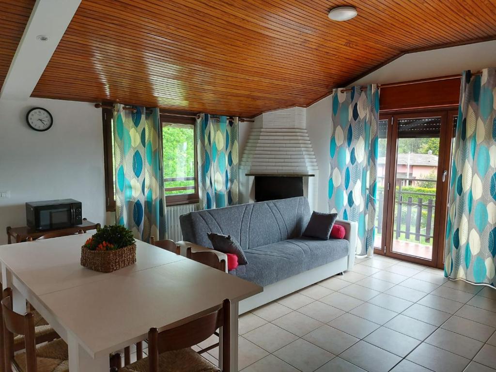 ein Wohnzimmer mit einem Sofa und einem Tisch in der Unterkunft Bnbook Casa dei Peschi - Lago di Monate in Cadrezzate