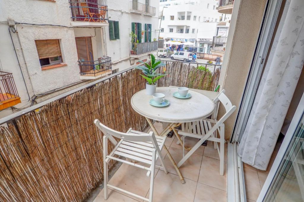 a small white table and chairs on a balcony at Gloria Apartment by Hello Homes Sitges in Sitges