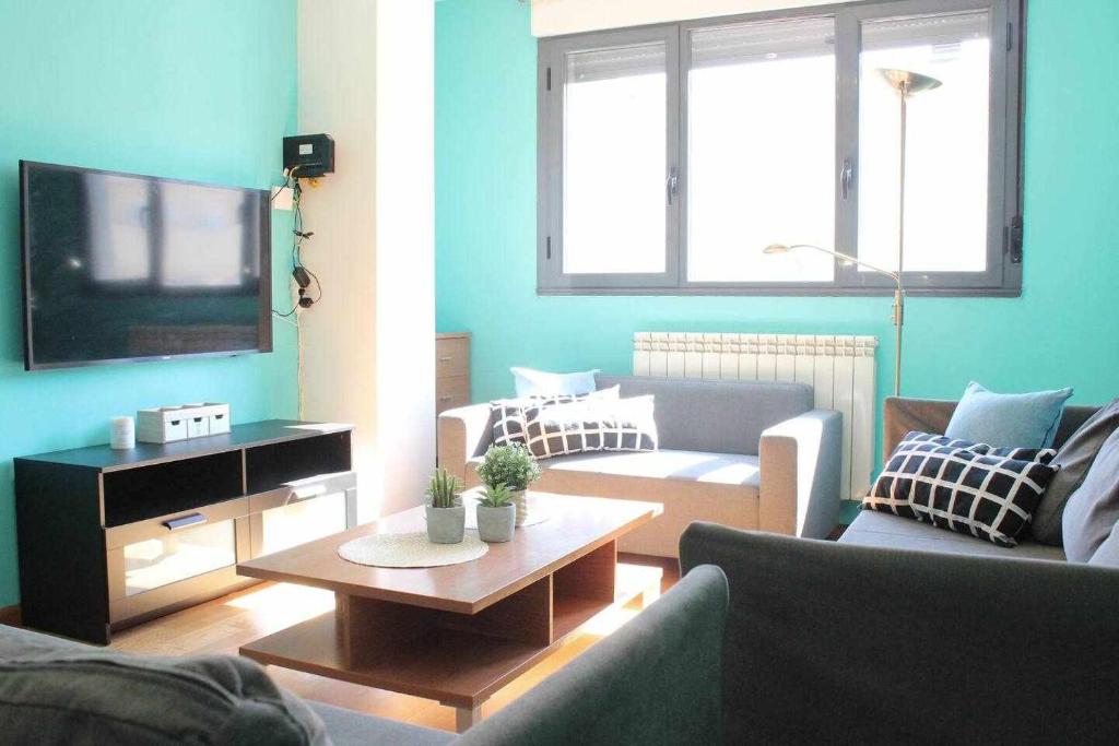 a living room with a couch and a tv at Espacioso piso leon vut227 in León