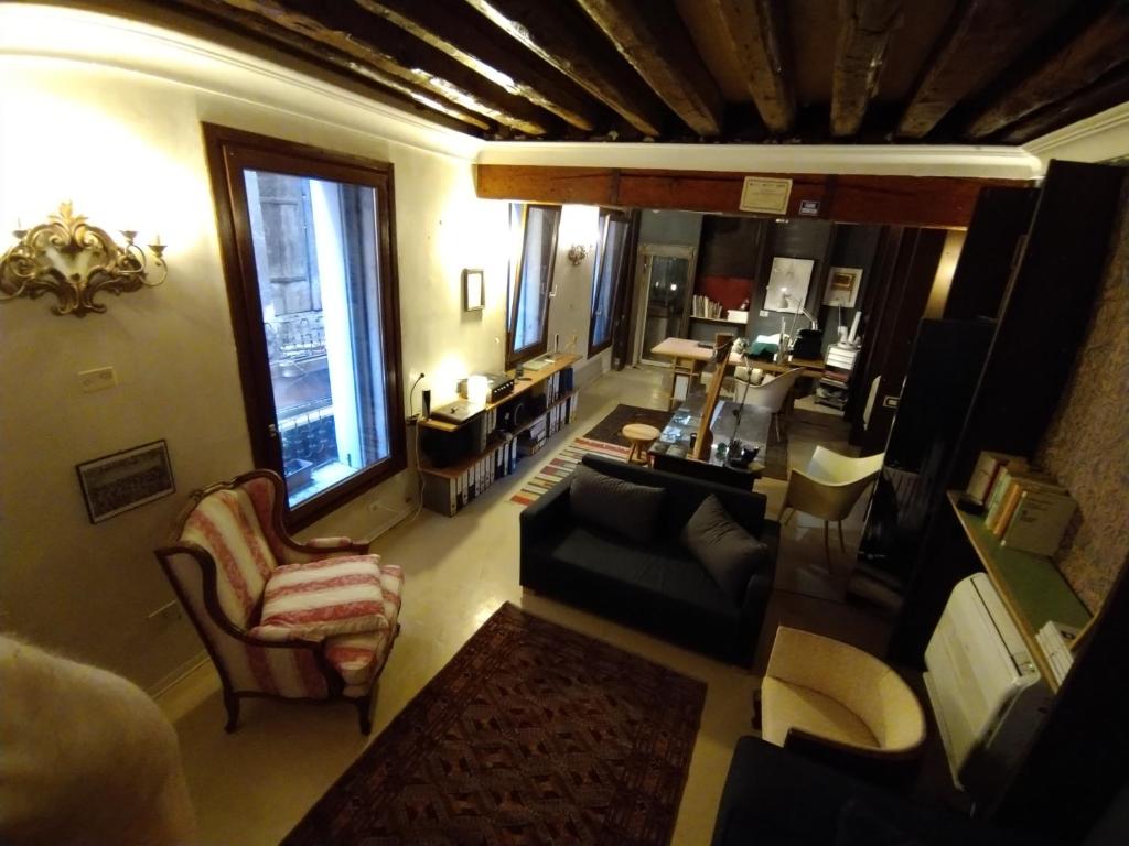 uma vista superior de uma sala de estar com um sofá e cadeiras em Studio Apartment San Marco 1825 fully sanitzd em Veneza