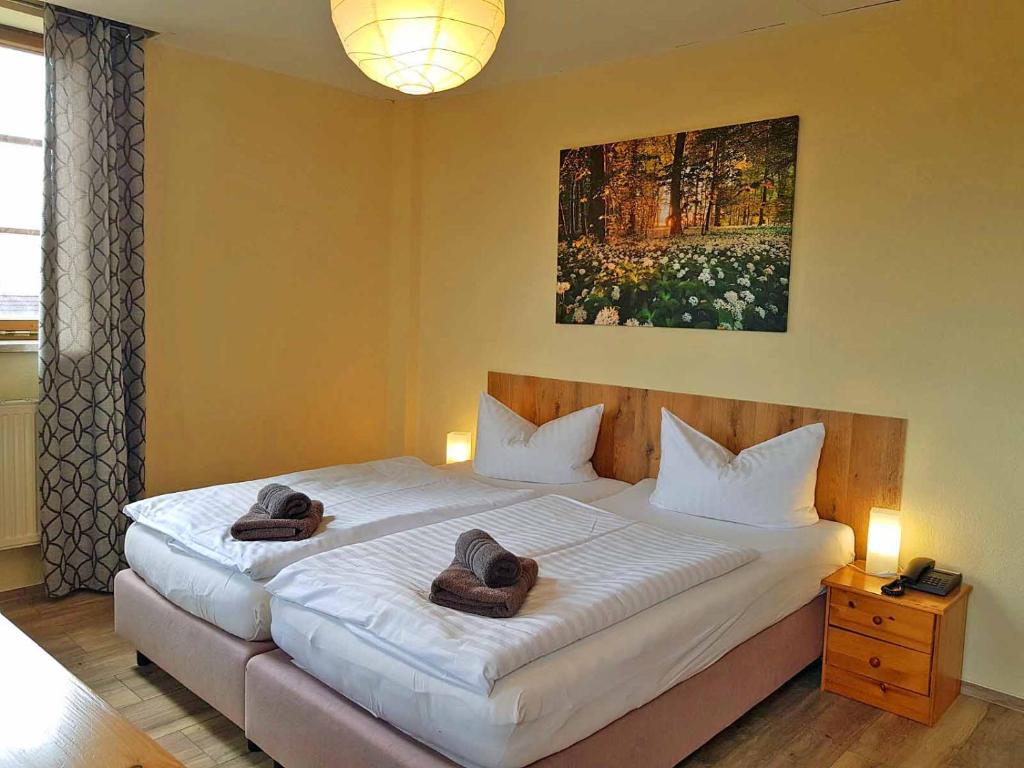 a bedroom with a large bed with two towels on it at Landhotel Edelhof in Uhlstädt