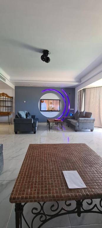 a living room with a table and a tv at درة العروس كورال بيتش فيلا in Durat Alarous