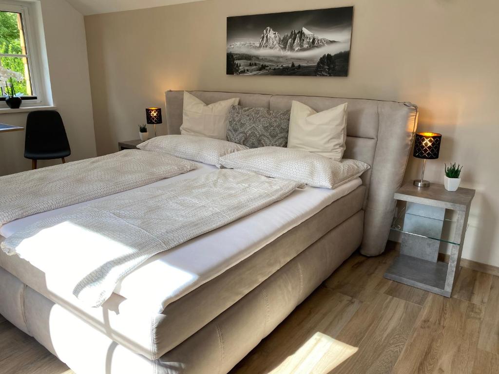 ein großes Bett mit weißer Bettwäsche und Kissen im Schlafzimmer in der Unterkunft Im Kurpark in Bad Ischl