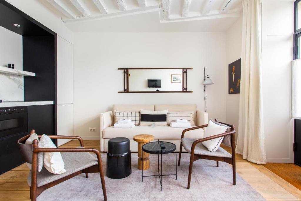 un salon avec un canapé, une table et des chaises dans l'établissement Cozy Apartment -2BR-6P- Cathédrale de Notre-Dame, à Paris