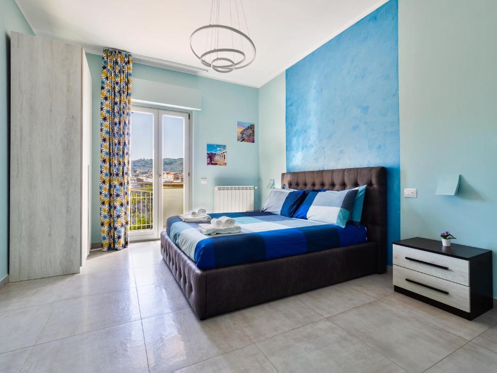 een blauwe slaapkamer met een bed en een raam bij Blue Sky Sorrento Apartment FREE PARKING in Meta