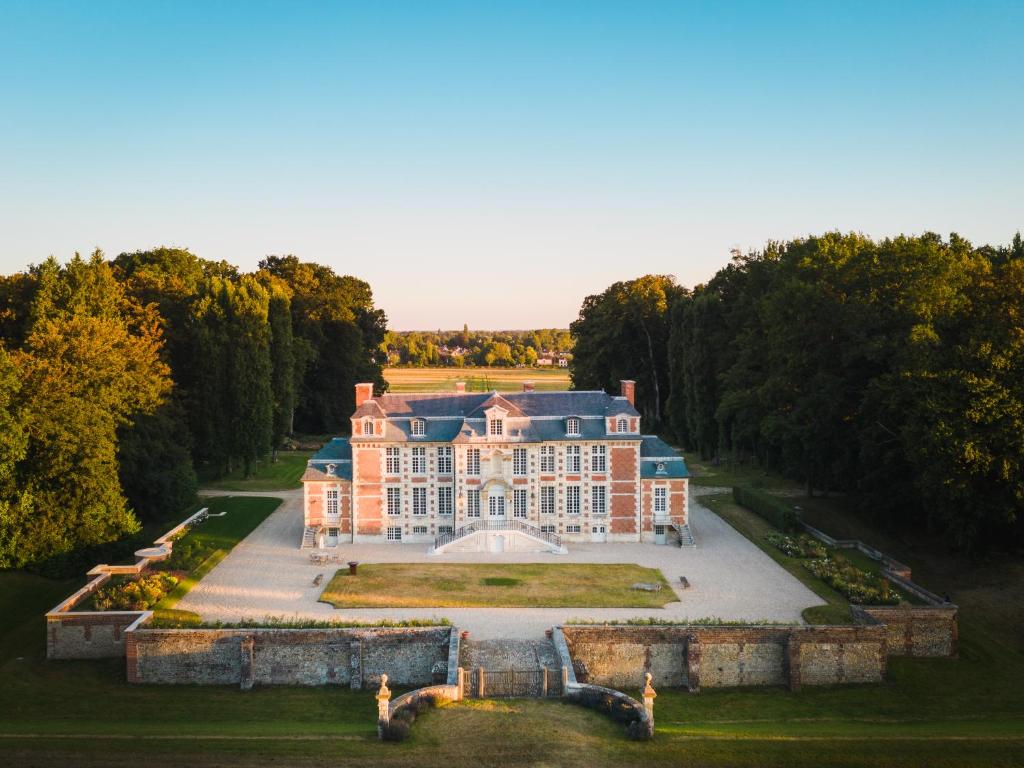 - une vue aérienne sur un grand manoir arboré dans l'établissement Chateau de St MACLOU, à Saint-Maclou