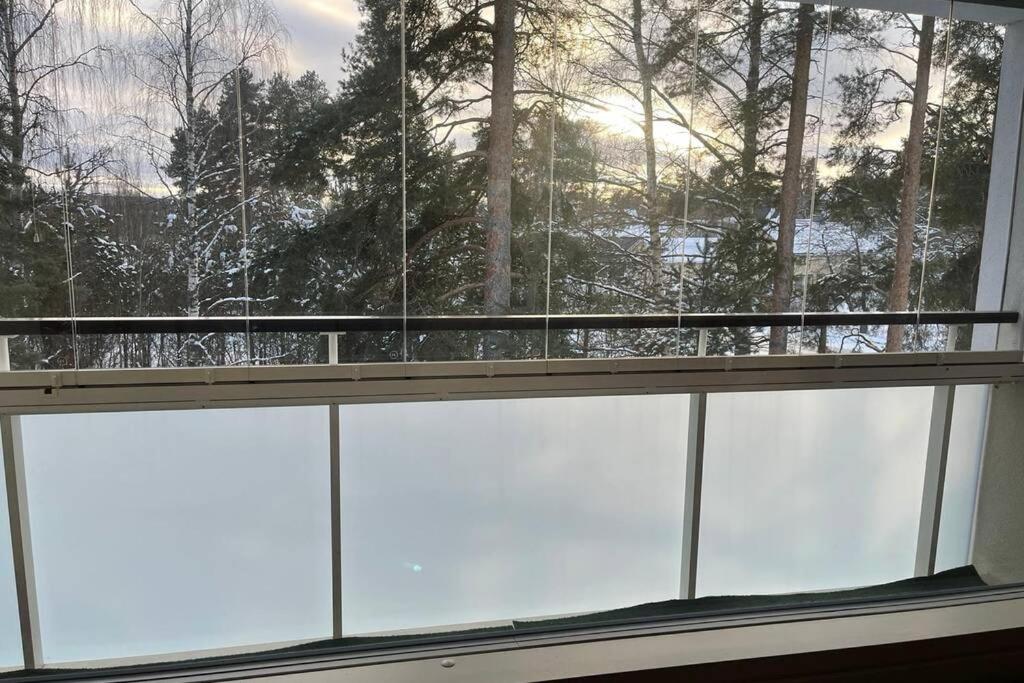 a window with a view of a snow covered forest at Olivia apartment Porvoo in Porvoo