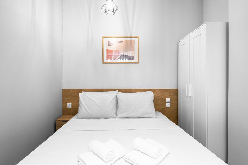 sypialnia z łóżkiem z białą pościelą w obiekcie Nemea Apartments, The Luxury Suites w Salonikach