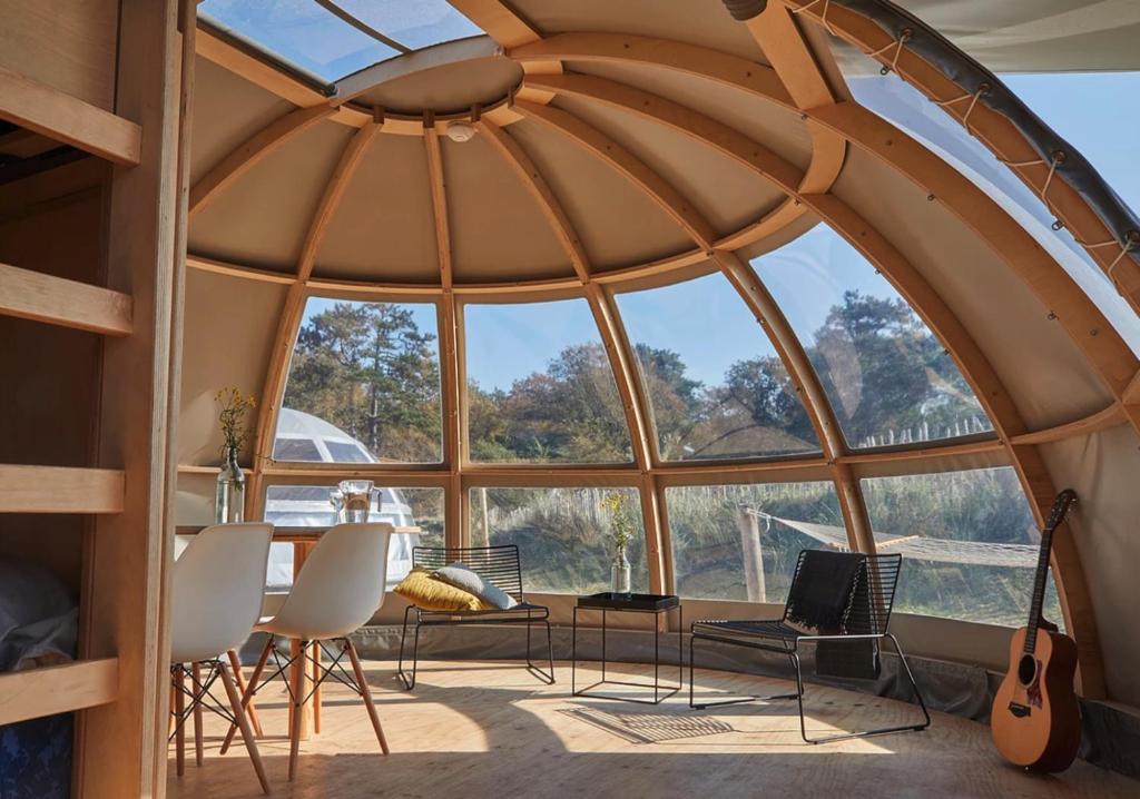 Zimmer mit einem großen runden Fenster mit einem Tisch und Stühlen. in der Unterkunft Riverdome met privé sanitair - en weids uitzicht - NIEUW 2021 in Zuna