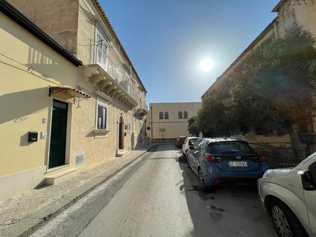 une rue avec des voitures garées sur le côté d'un bâtiment dans l'établissement Casa Crispi, à Noto