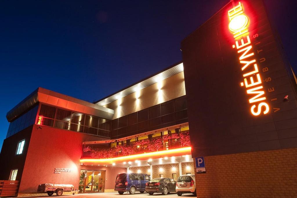 un hotel con auto parcheggiate fuori di notte di Smėlynė a Panevėžys
