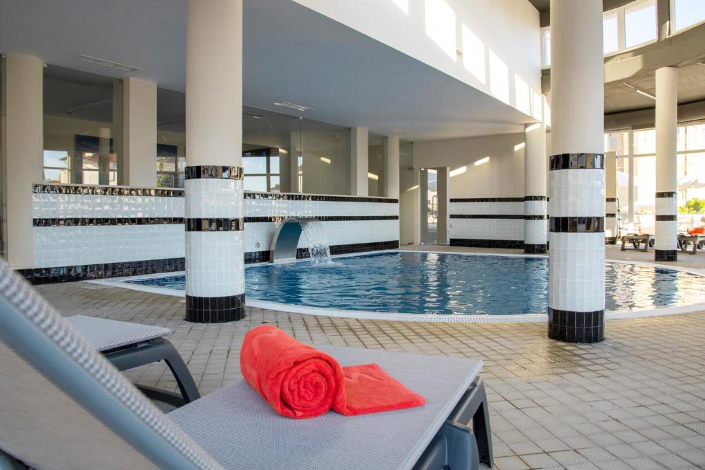 uma piscina do hotel com uma toalha vermelha numa cadeira em Luna Hotel de Tbua na Tbua