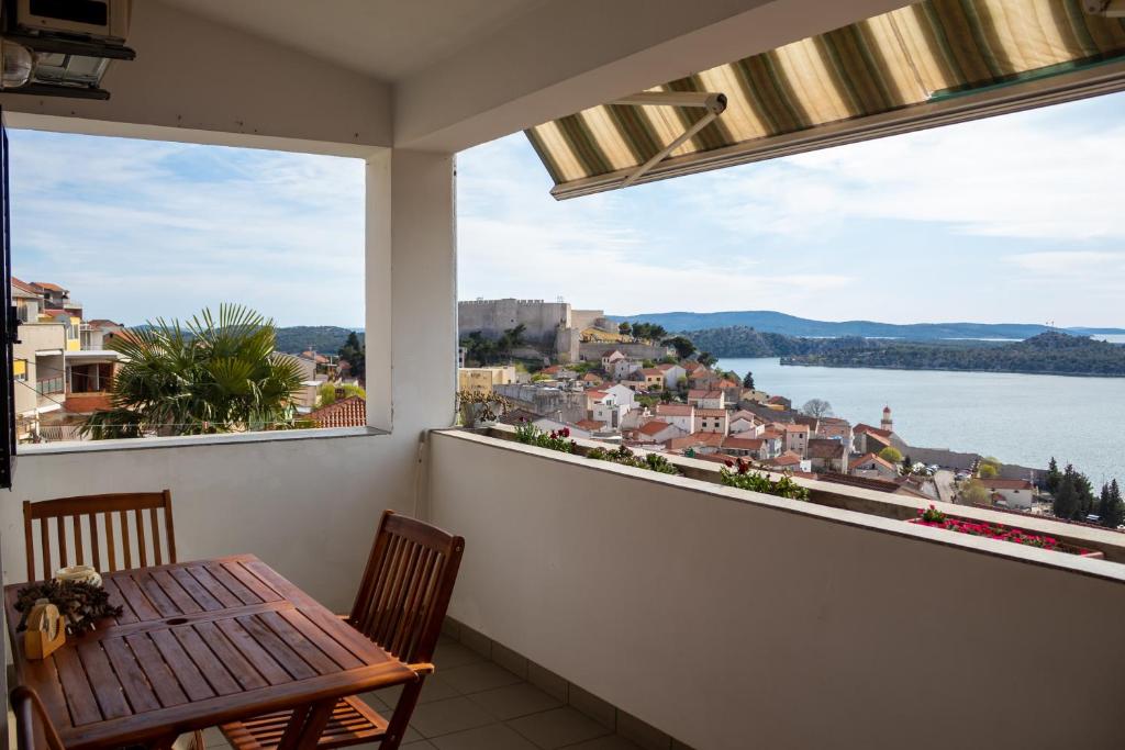 balcone con tavolo e vista sull'acqua di Apartments Ana+3 a Šibenik