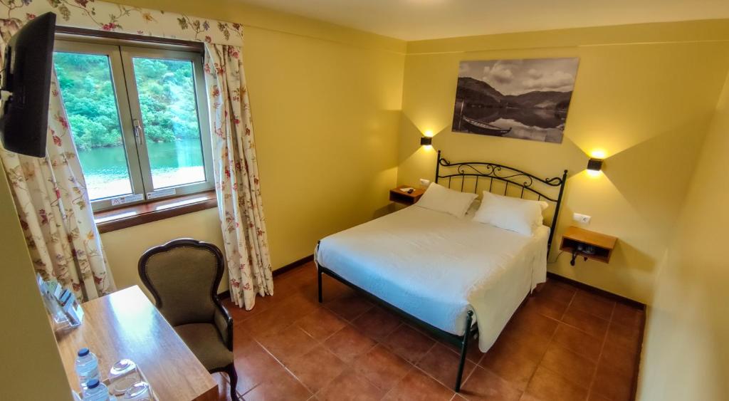 Schlafzimmer mit einem Bett und einem Fenster in der Unterkunft Hotel Casa do Tua in Foz Tua