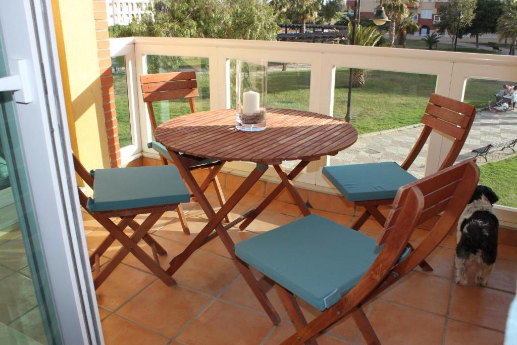 un tavolo e sedie su un balcone con tavolo di APARTAMENTO LAS PALMERILLAS-RESIDENCIAL TORREQUEBRADA a Roquetas de Mar