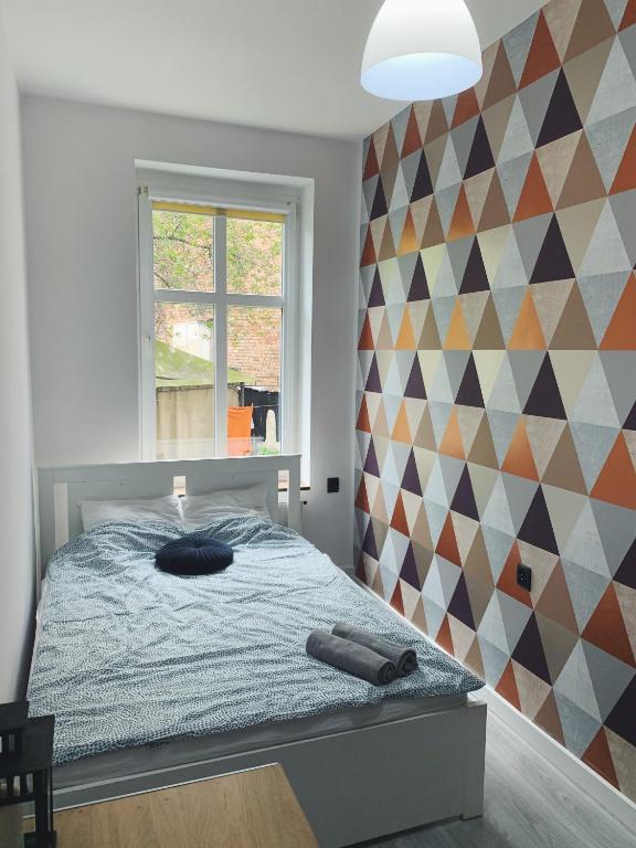 a bedroom with a bed and a geometric wall at Rooms4Less in Gdańsk