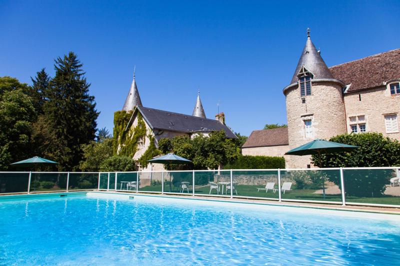 uma grande piscina em frente a um edifício em Château de Bellecroix em Chagny