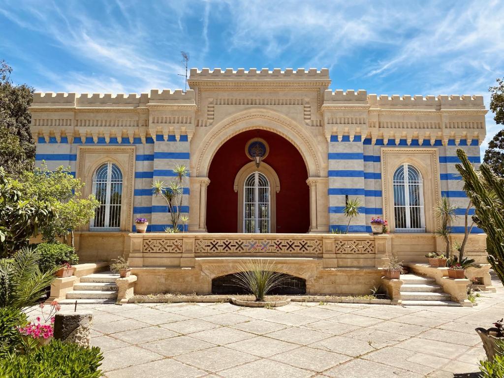 un edificio con rayas azules y blancas en La Serra - Villa De Bonis, en San Cesario di Lecce