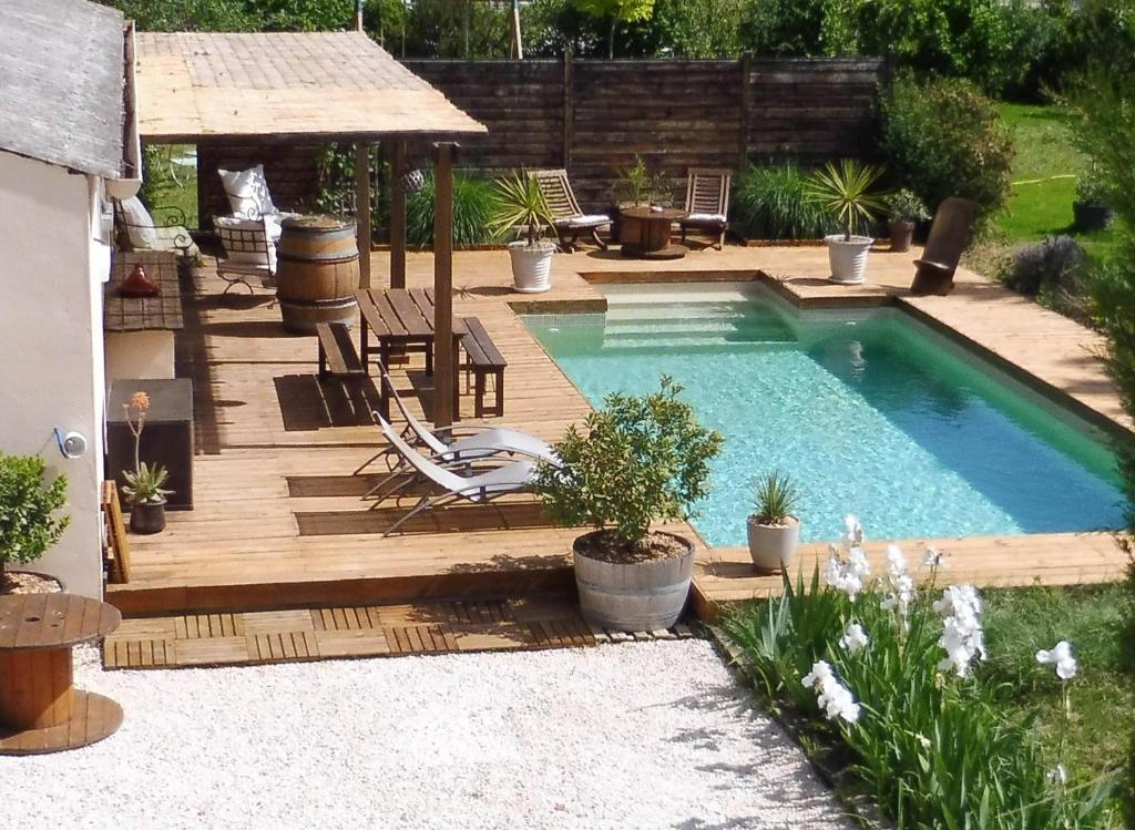 a backyard pool with a wooden deck and a swimming pool at Mas des Rabasses in Le Pontet