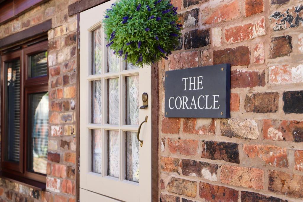 a door to a brick building with a sign that reads the concrete at The Coracle in Ironbridge