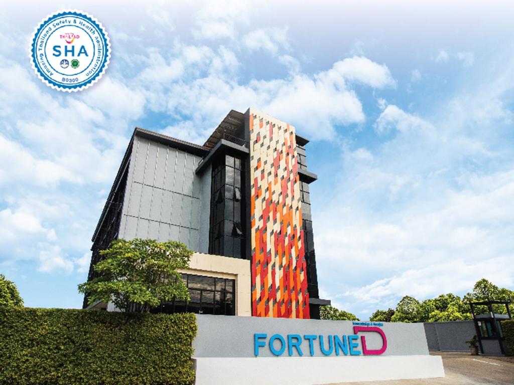 un edificio con una señal de futuro delante de él en Fortune D Hotel Phitsanulok, en Phitsanulok