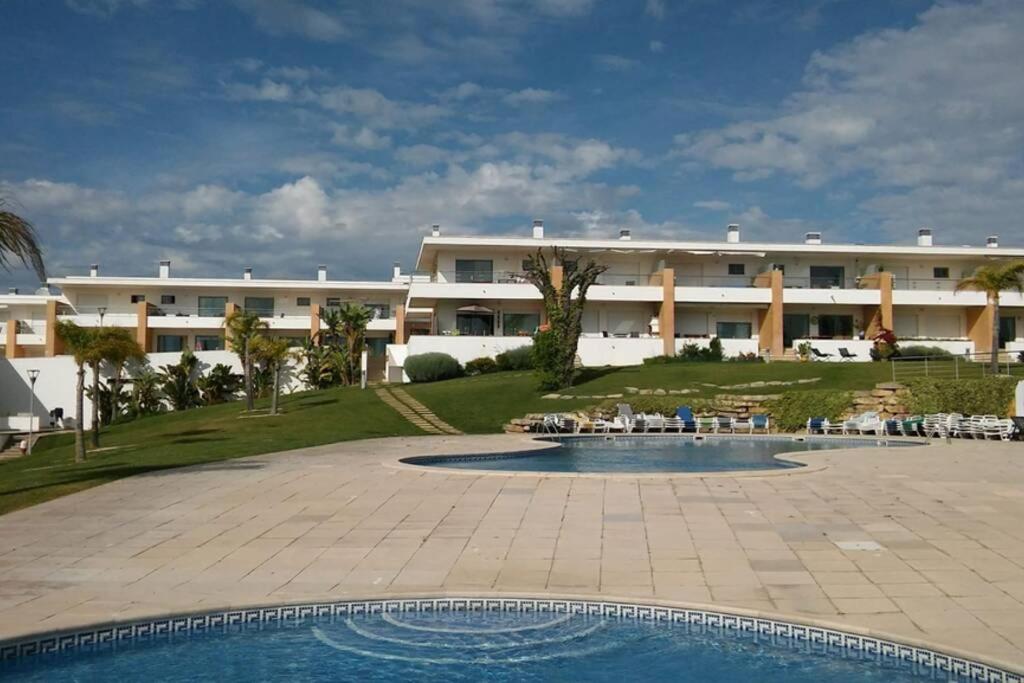 un grand bâtiment avec une piscine en face d'un bâtiment dans l'établissement Apartamento Albufeira, à Albufeira