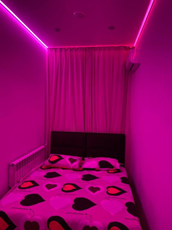 a pink room with a bed with a pink ceiling at Olesi Gonhara in Dnipro