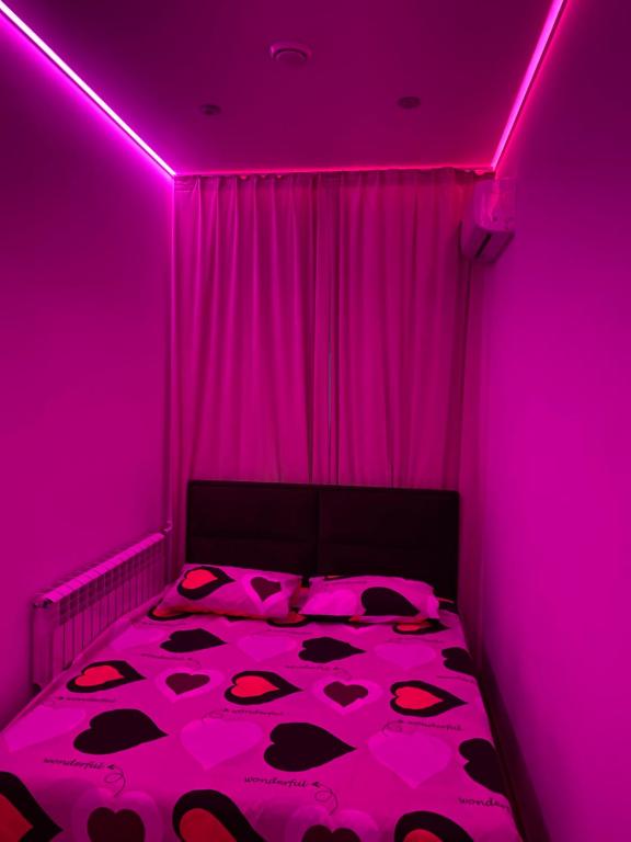 a pink room with a bed with a pink ceiling at Olesi Gonhara in Dnipro