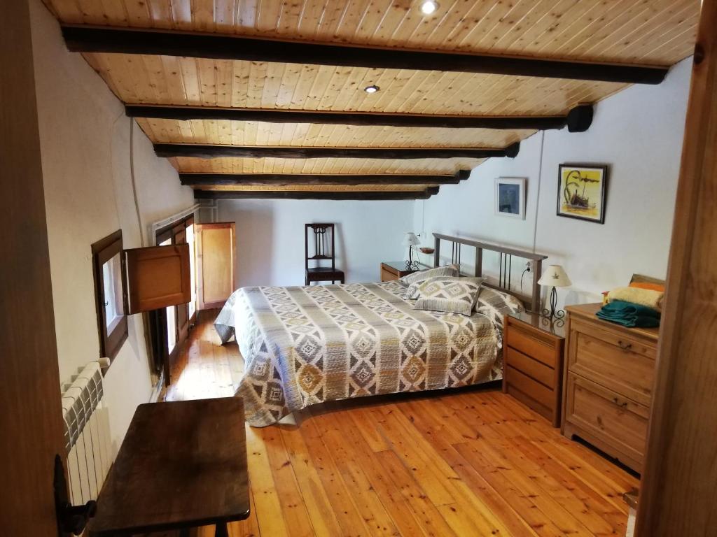 1 dormitorio con cama y techo de madera en Cal Bové, en Sant Guim de Freixenet